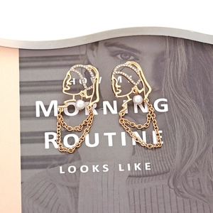 Vintage face silhouette earrings with rhinestones and pearl drops on a magazine background