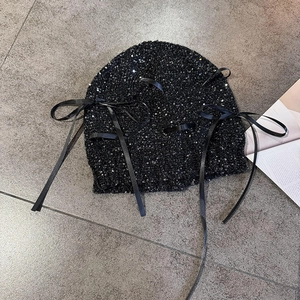 Detail der schwarzen Pailletten-Beanie mit langen Satinbändern und Schleifen-Akzenten