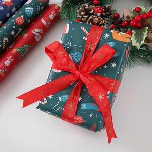 Close-up of Christmas gift boxes with gold foil elk ribbons and festive patterned wrapping paper