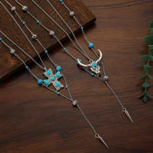 Dettaglio della collana boho turchese con pendenti testa di bufalo e croce argento