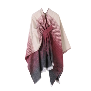 Ethnic style knitted poncho with gradient color design and fringe details on white backdrop