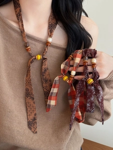 Close-up of Bohemian fabric printed necklaces with vintage wooden and resin beads