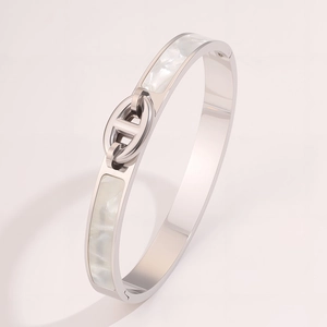 Detailed macro shot of silver stainless steel cuff with white mother-of-pearl inlay detail