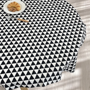 Detail of round cotton tablecloth with black and white geometric triangle patterns
