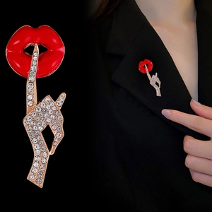 Red lip and shush gesture brooch with gold metal and white rhinestones on black blazer