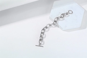 Detailed view of silver thick link chain bracelet with OT toggle clasp on marble tile