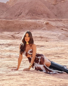 Detail of tie-dye backless maxi dress with side slit and gold accessories in desert setting