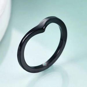Macro detail of high-gloss black V-shaped titanium steel ring with mirror finish texture