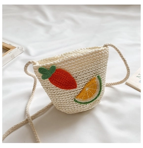 Dettaglio della borsa in paglia per bambini con ricami a carota e fetta d'arancia