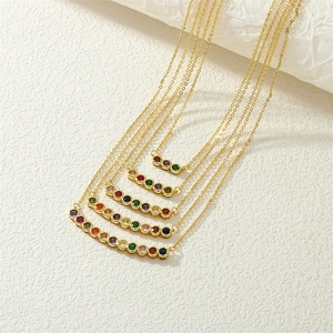 Rainbow gemstone 18K gold plated necklaces in multiple lengths on a stone background