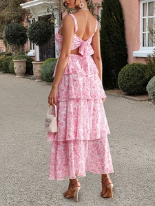 Back view of pink floral chiffon dress with multi-layer ruffles in a garden setting