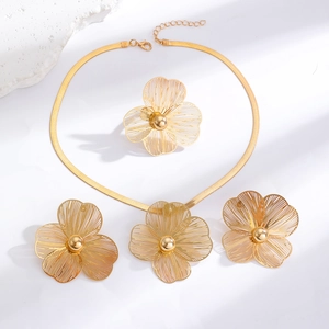 Detail of gold floral jewelry set with intricate hollow petals and polished center beads