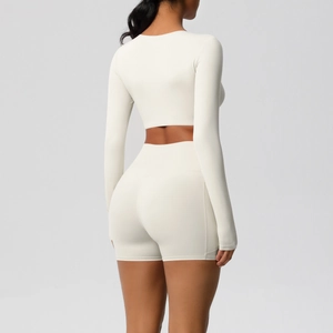Achteraanzicht van een crèmekleurige yoga-set voor dames met crop-top en korte broek