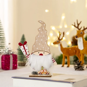 Detalle de gnomo navideño de madera con barba blanca y caja de regalo para escritorio