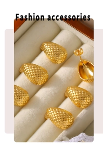 Macro shot of 18k gold plated teardrop earrings with intricate scale texture pattern
