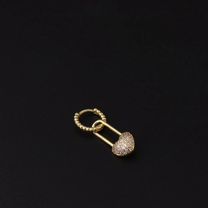 Detail of gold heart lock earring with micro-paved zircons and wavy textured hoop