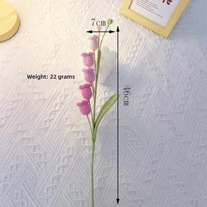 Detail of a handmade pink crochet lily of the valley flower, 46cm length with green leaves