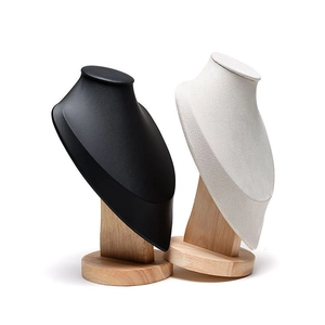 Detail of wooden base necklace busts in black faux leather and off-white velvet finishes