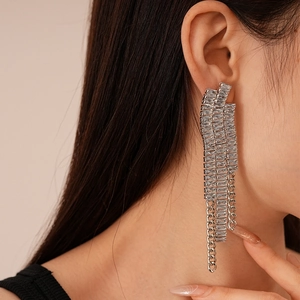 Gros plan de boucles d'oreilles pampilles en zircon avec de longues chaînes sur mannequin
