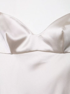 Detail of satin slip dress showing champagne silk texture and elegant V-neckline finish