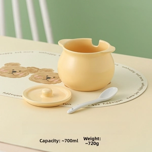 Detail of cream ceramic lard jar with lid and spoon on a cute bear dining mat