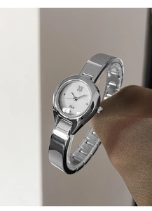 Detailed side view of luxury silver bangle watch with white Roman numeral dial