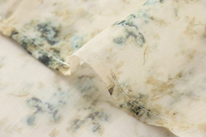 Vue macro d'un tissu floral léger avec des détails de couture d'ourlet et texture douce