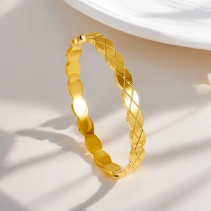 Detailed macro view of 18K gold plated bangle featuring classic quilted texture design