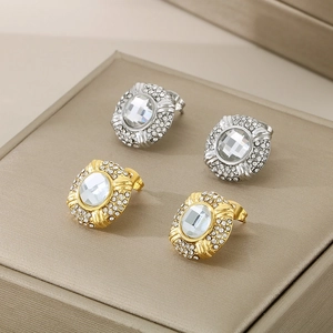 Detail of oval diamond-encrusted 18k gold and silver stainless steel stud earrings