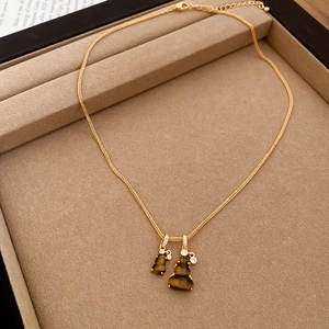 Macro shot of gold necklace with tiger eye hulu pendants on a velvet jewelry tray