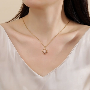 Rotating cat-eye flower necklace in gold finish with pink gemstone and crystal accents
