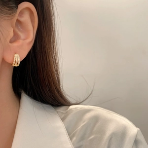 Three-row gold plated triple hoops with micro-set zircons on elegant female model