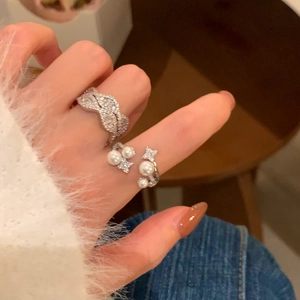 Detaillierte Ansicht des eleganten Wellenrings mit Zirkonia und Perlen-Akzent-Ring am Finger