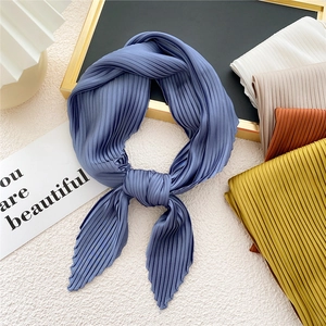 Elegant pleated silk scarf in blue with various colors displayed on textured background
