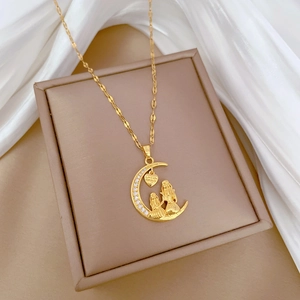 Close-up of gold moon and heart pendant with Love You Forever engraving on silk