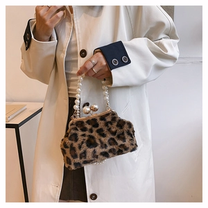 Detail of leopard print faux fur handbag with pearl chain and gold metal spherical clasp