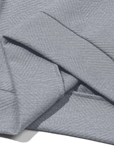 Détail du tissu jacquard gris avec texture à chevrons et coutures de surjet renforcées