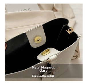 Close-up of white lychee leather handbag with premium golden magnetic buckle closure