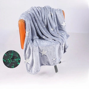 Detail of glow-in-the-dark stars on soft light grey flannel blanket for couch and bedding