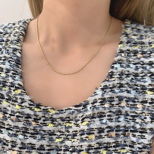 Detail shot of 18K gold plated rice grain chain necklace on model neck