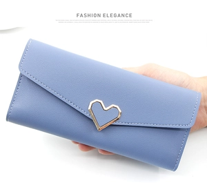 Detail der hellblauen Ledergeldbörse mit herzförmiger Metallschnalle in der Hand