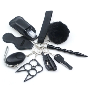 Detail of multi-functional black keychain set with safety alarm and fluffy pom pom