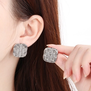 Close-up of silver square woven texture earrings on model with high clarity detail