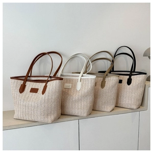 Detailed view of straw woven tote bags in four colors with premium leather straps