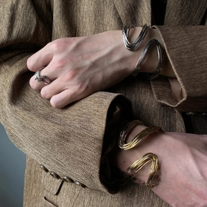 Detailed view of layered twisted metal bracelet and matching ring on a model