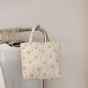 Détail du sac à main matelassé à fleurs avec étiquette simple wish et texture souple