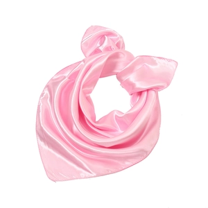 Close-up of pink satin square scarf with silky luster and smooth texture on white background