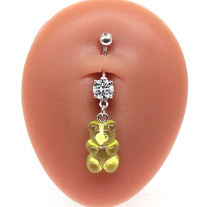 Detailed view of a yellow gummy bear belly button ring with zircon stones on skin model