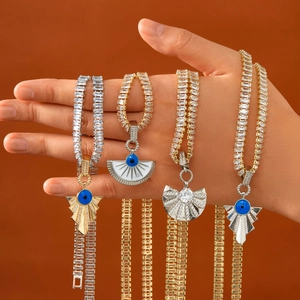 Close-up of hip hop evil eye pendants with hand-set cubic zirconia on gold and silver tennis chains