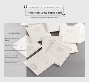 Macro detail of white jewelry display cards showing linen texture and gold foil stamping